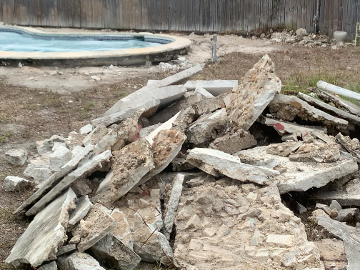 Casa Citron pool deck before renovation showing weeds and temporary concrete slab debris