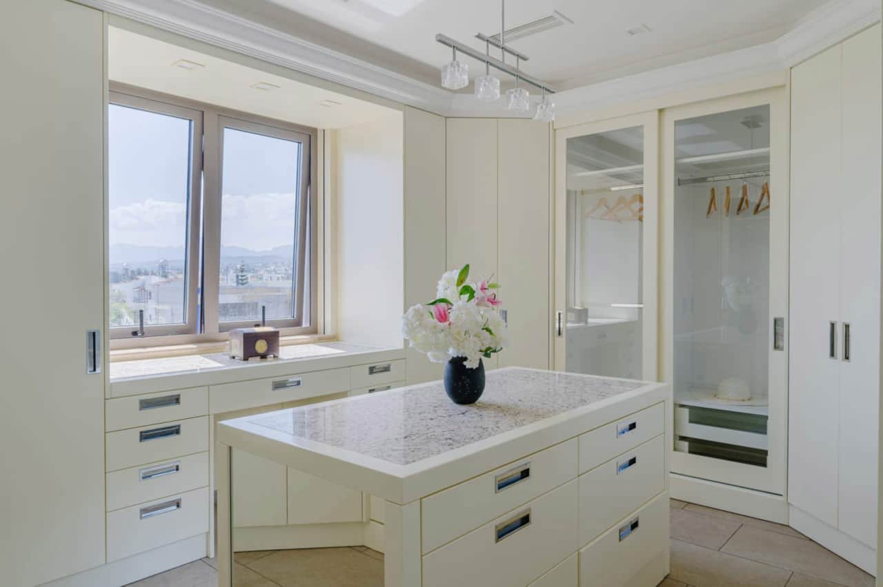 Dressing room with plenty of storage and natural light, leading from the bathroom and hallway.