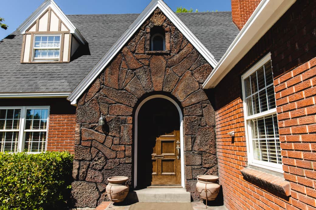 Arched stone entry and classic wood door offer a warm Tudor welcome Arched stone entry and classic wood door offer a warm Tudor welcome