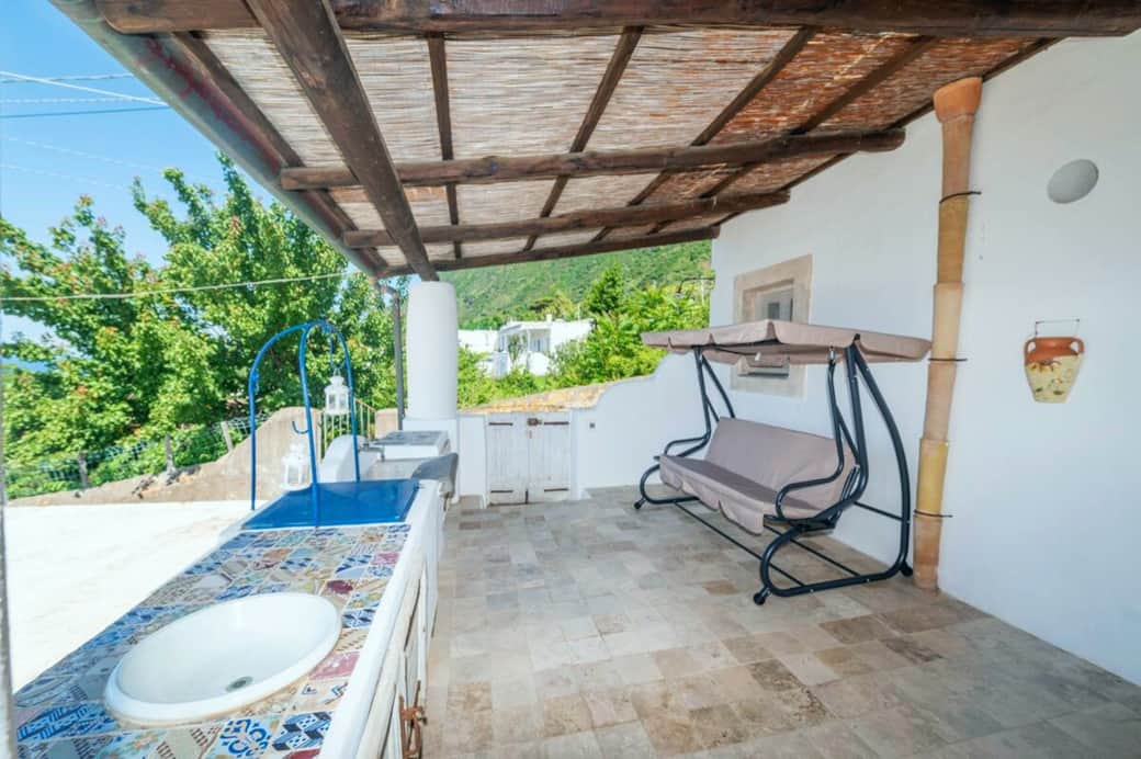 Zona esterna attrezzata con dondolo e lavabo, perfetta per momenti di relax immersi nel verde.