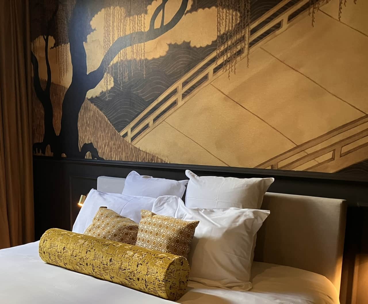 Close-up of the Elisabeth Suite bed with headboard and its wallpaper mural