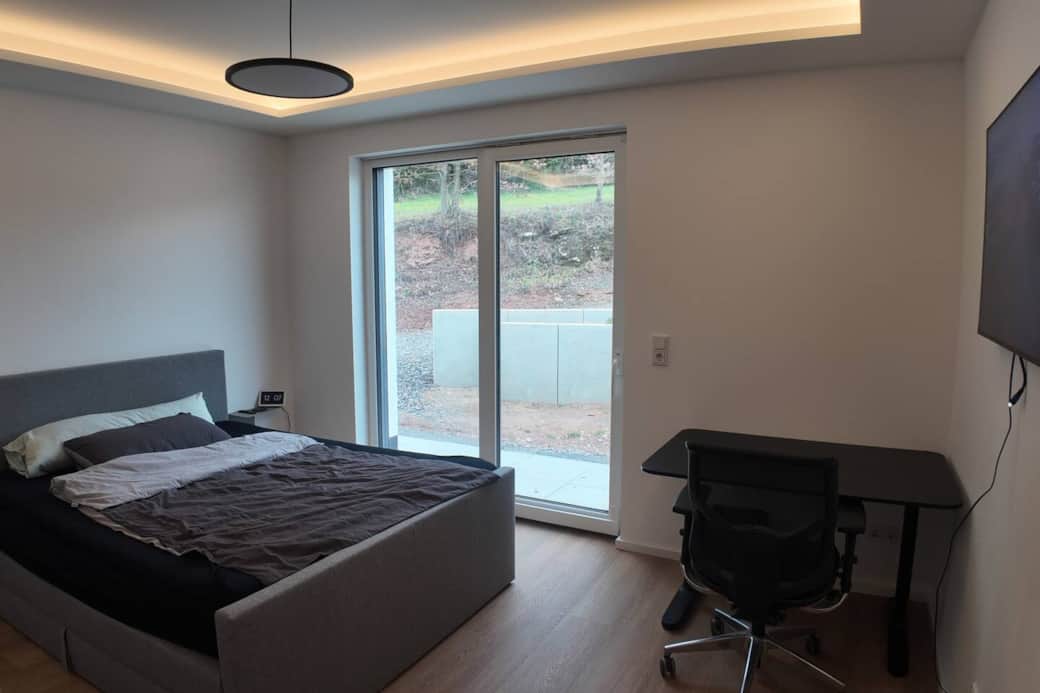 Schlafzimmer mit Queensize-Bett, Schreibtisch und TV