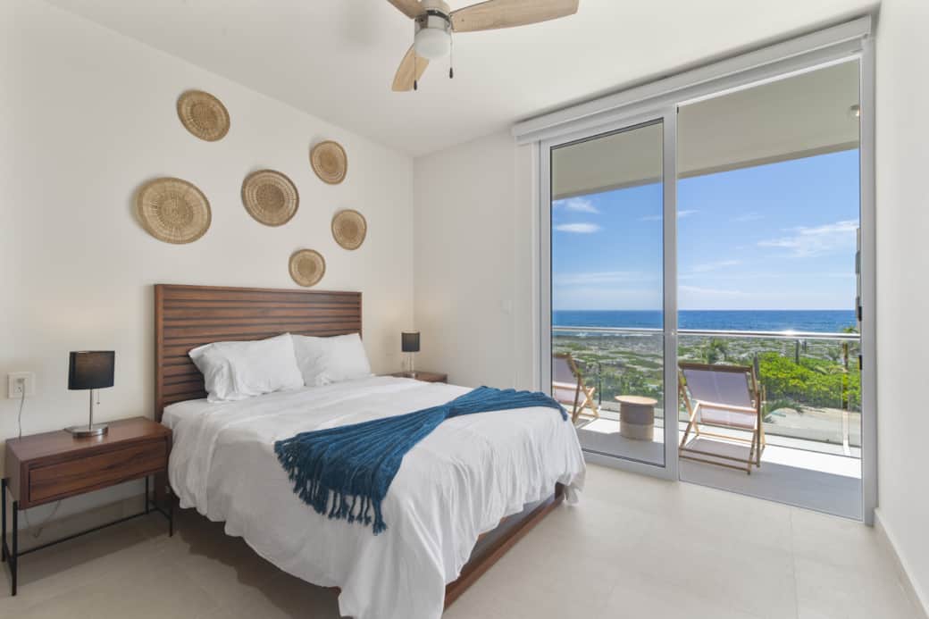 Bedroom 1: Cozy queen bed, soft linens, and private ocean-view balcony.