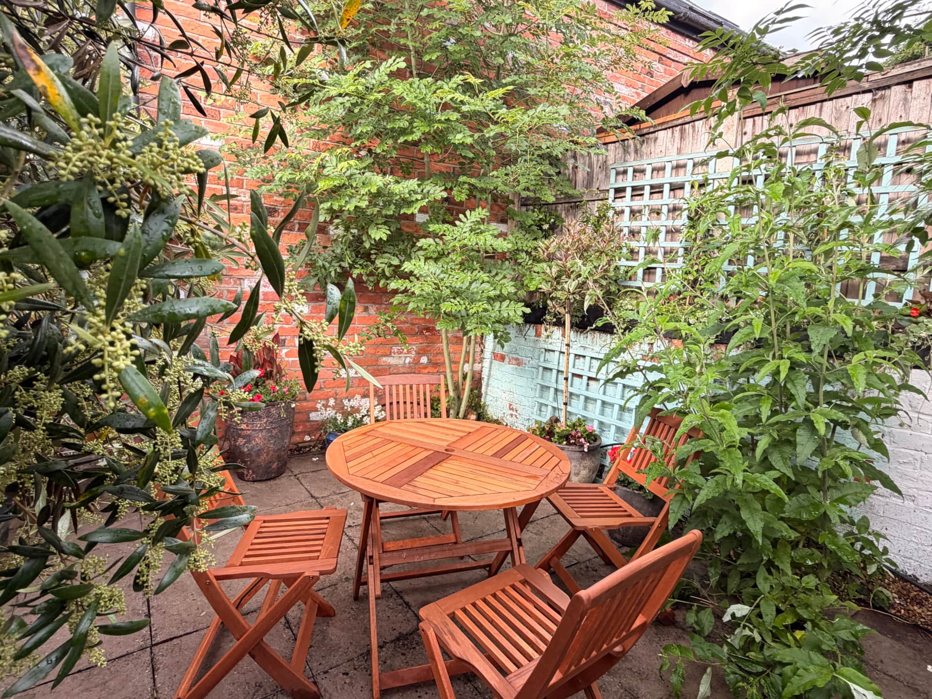 Wooden table and chairs in the Jasmine Cottage courtyard garden