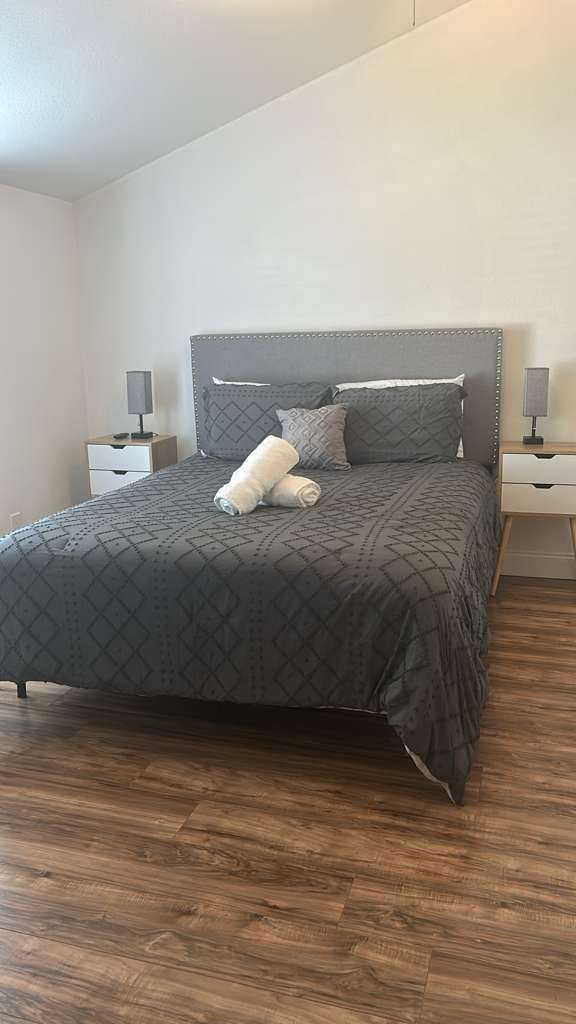 Charming queen room with elegant lamps, nightstands, and cool AC. Lakeland, FL