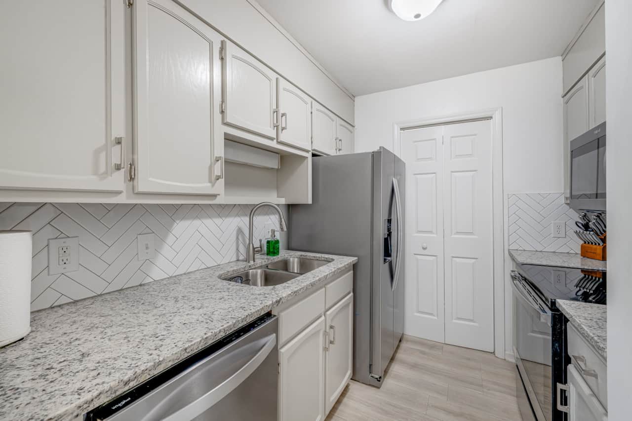 Kitchen with herringbone tile backsplash and granite counters