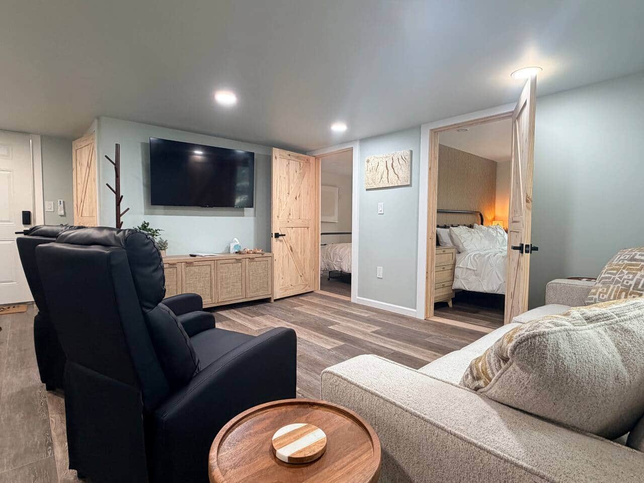 Living room area with 55” smart TV, recliners, and couch.