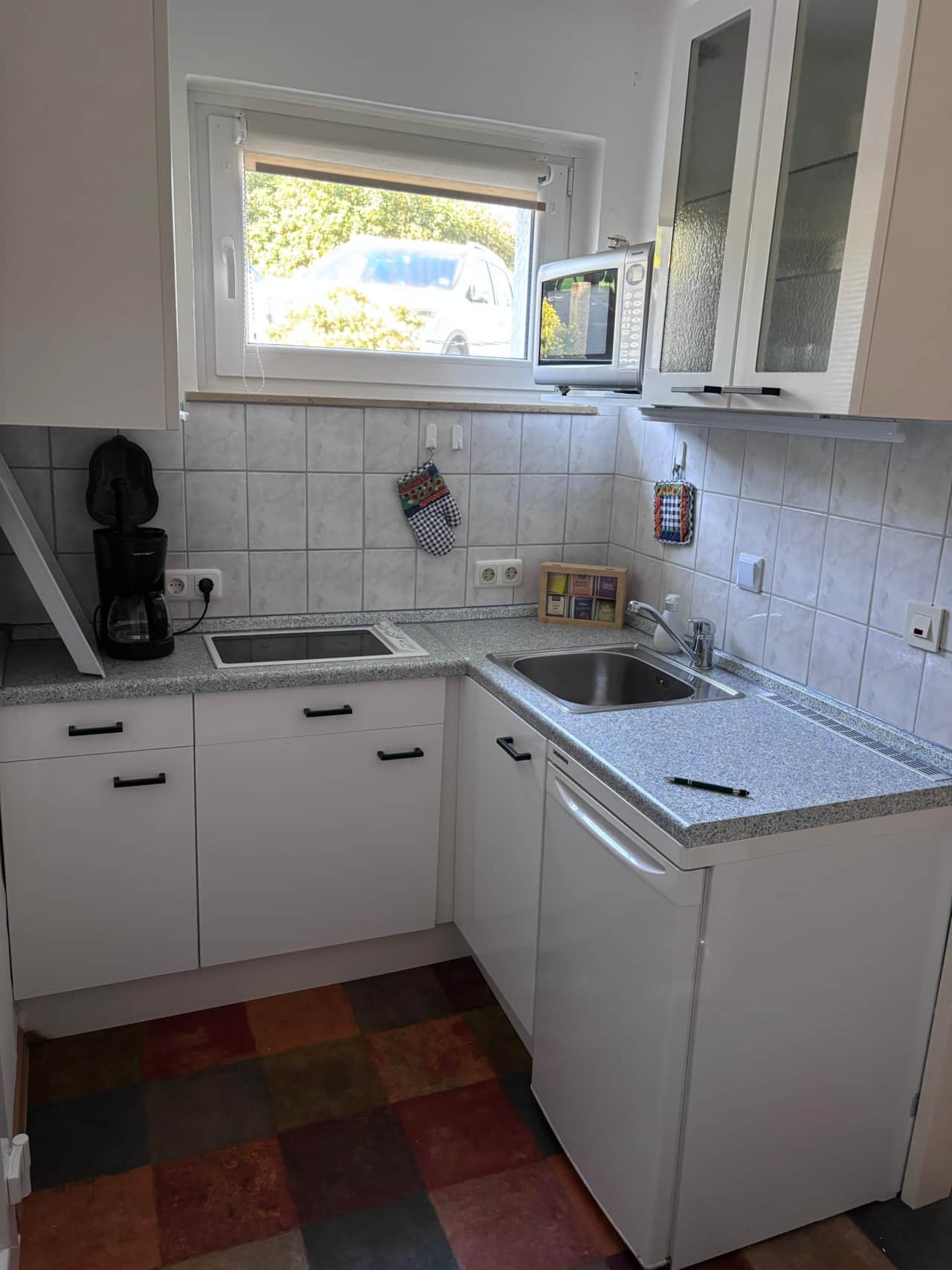 Voll ausgestattete Küche für Selbstversorger: Mit Cerankochfeld, Mikrowelle und Kaffeemaschine findest du hier alles für dein perfektes Frühstück oder ein entspanntes Abendessen. Kompakt, sauber und direkt am Fenster.