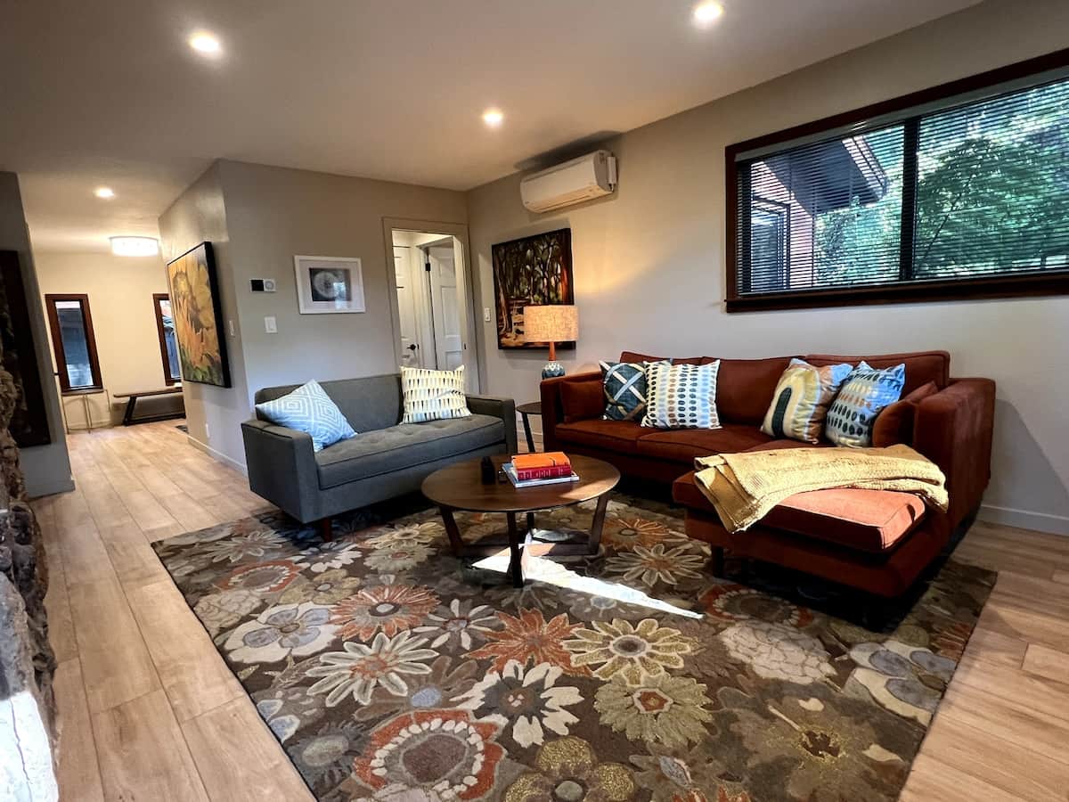 TV Room / Den on the home's first floor. Entry to bathroom and Queen bedroom in background right. Sliding door can close off bathroom for exclusive use for bedroom guests. This bedroom is best suited for guests with difficulty navigating stairs.