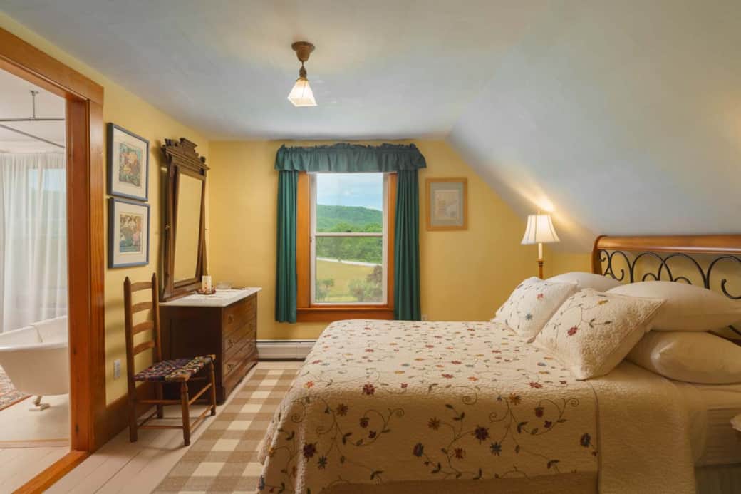 Sunrise Room with queen bed and a private bath featuring a claw-foot tub and views.