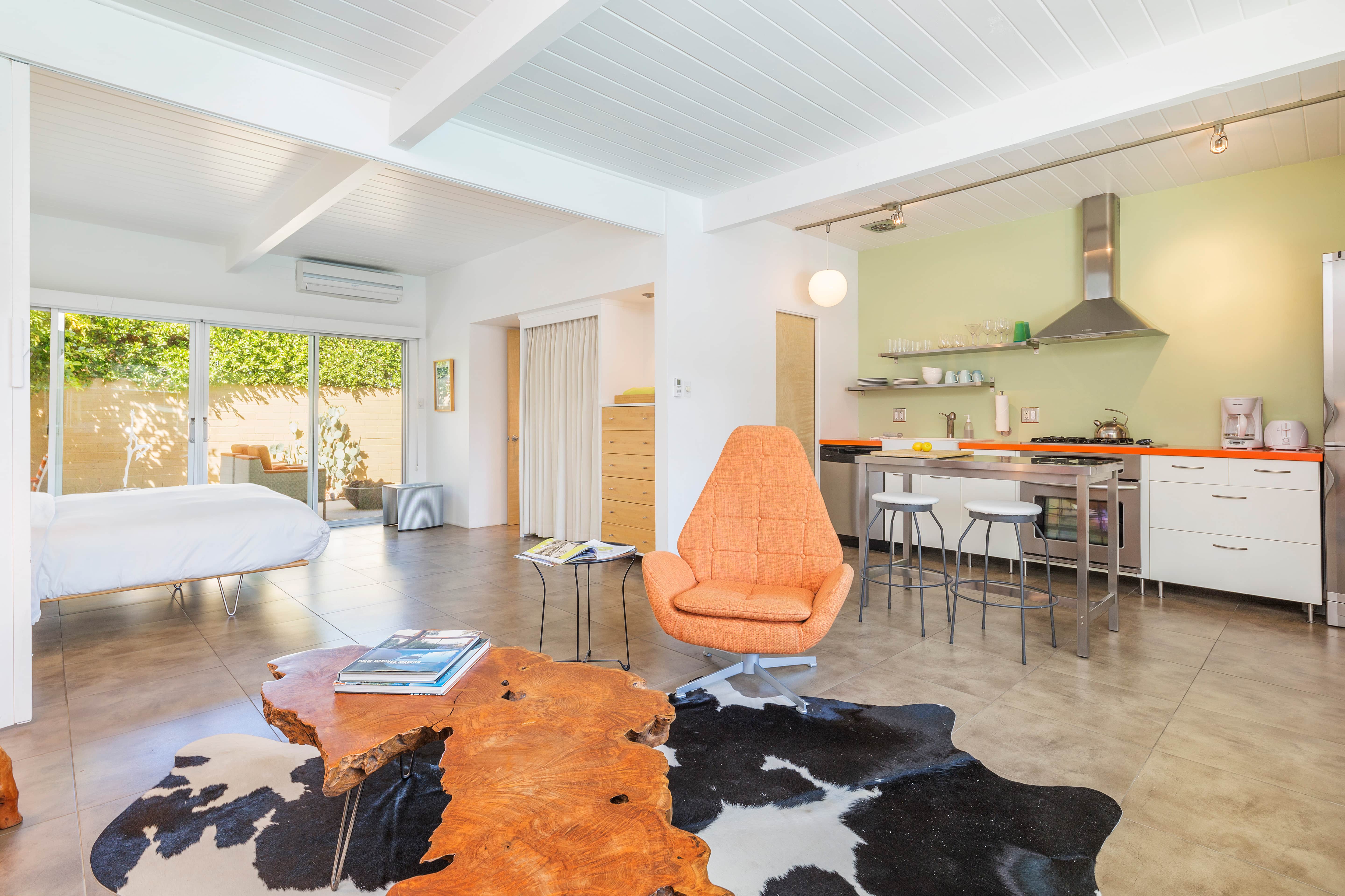 A wide view of a modern suite with kitchen, living area, and bedroom