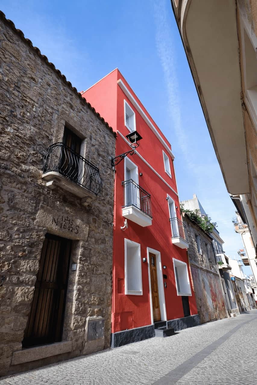 Via Cavour 31-A Olbia — historic red facade exterior in Olbia city centre, long-term rental apartment managed by nr12, available on Idealista and Immobiliare.it