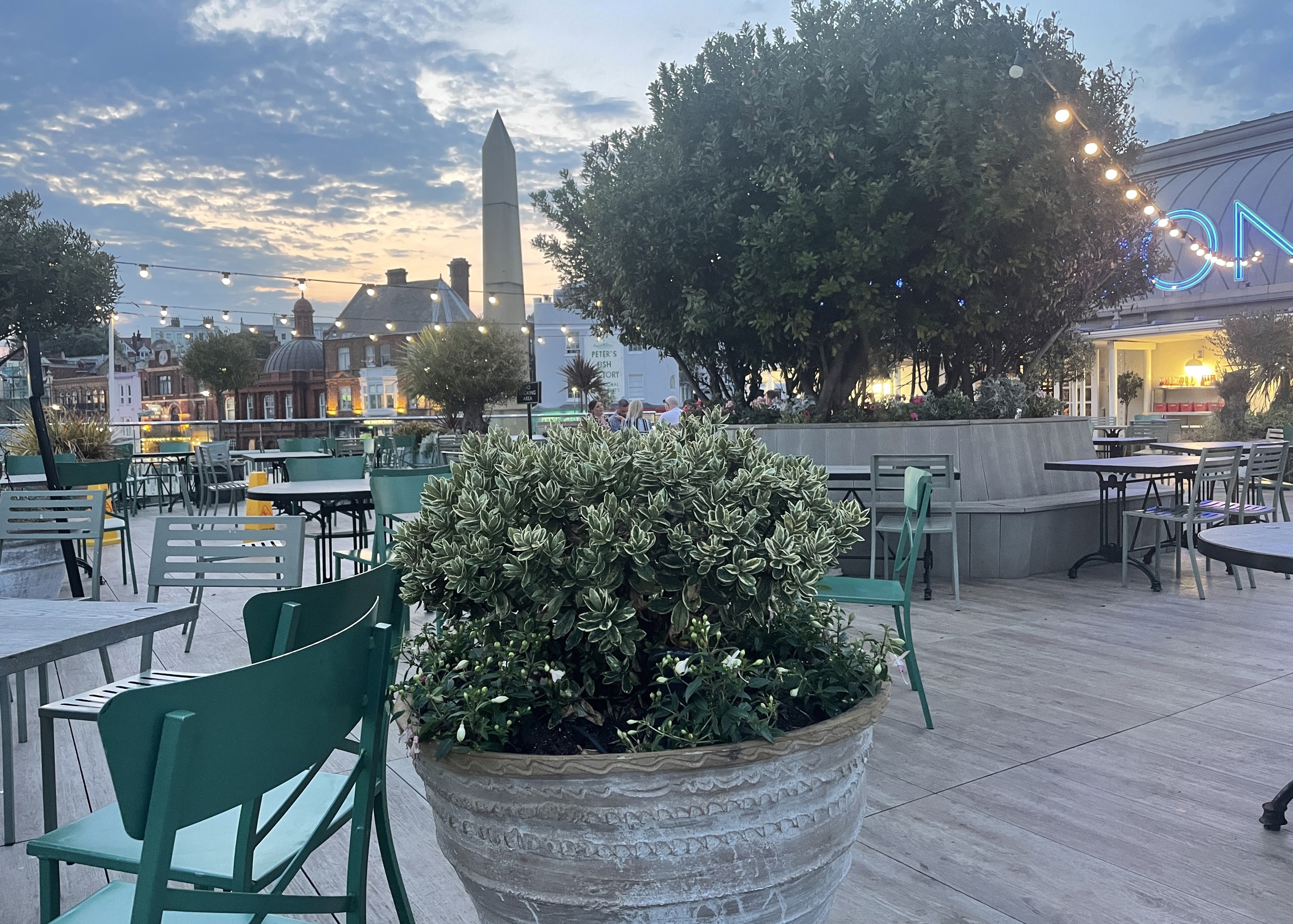 Outdoor Cafe with potted shrubs by night