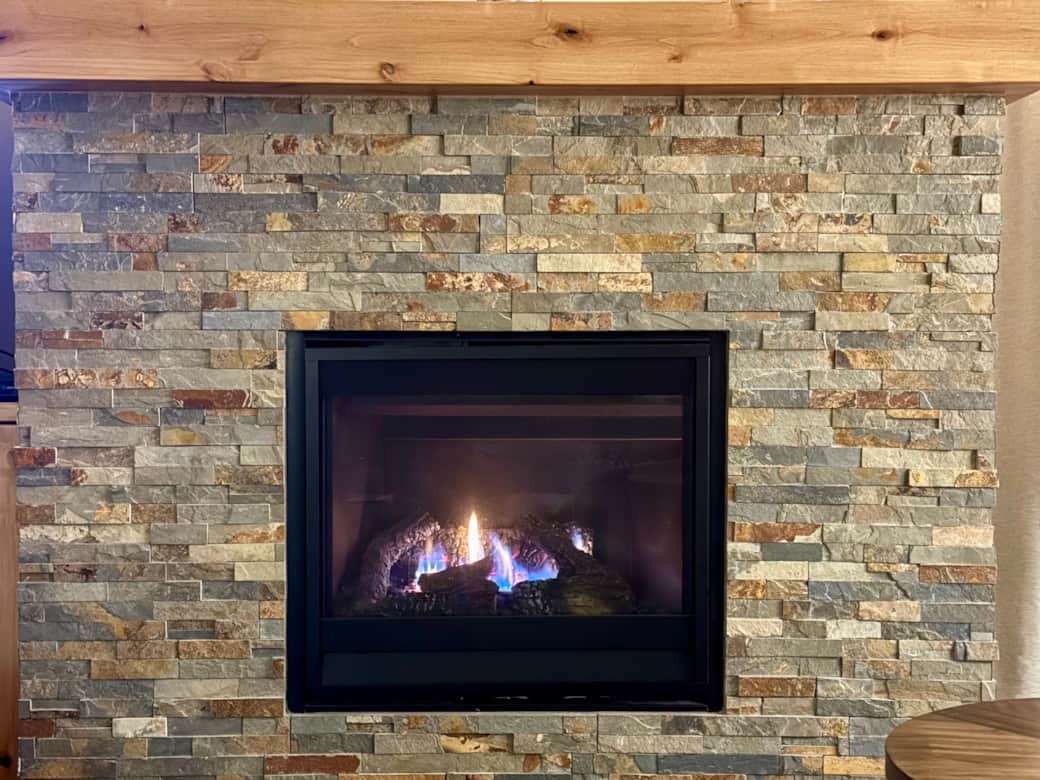Gas fireplace with stacked stone surround – perfect for Central Oregon evenings