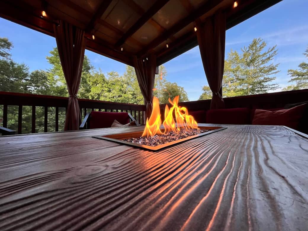 Screened-in back porch fire table usable year-round.