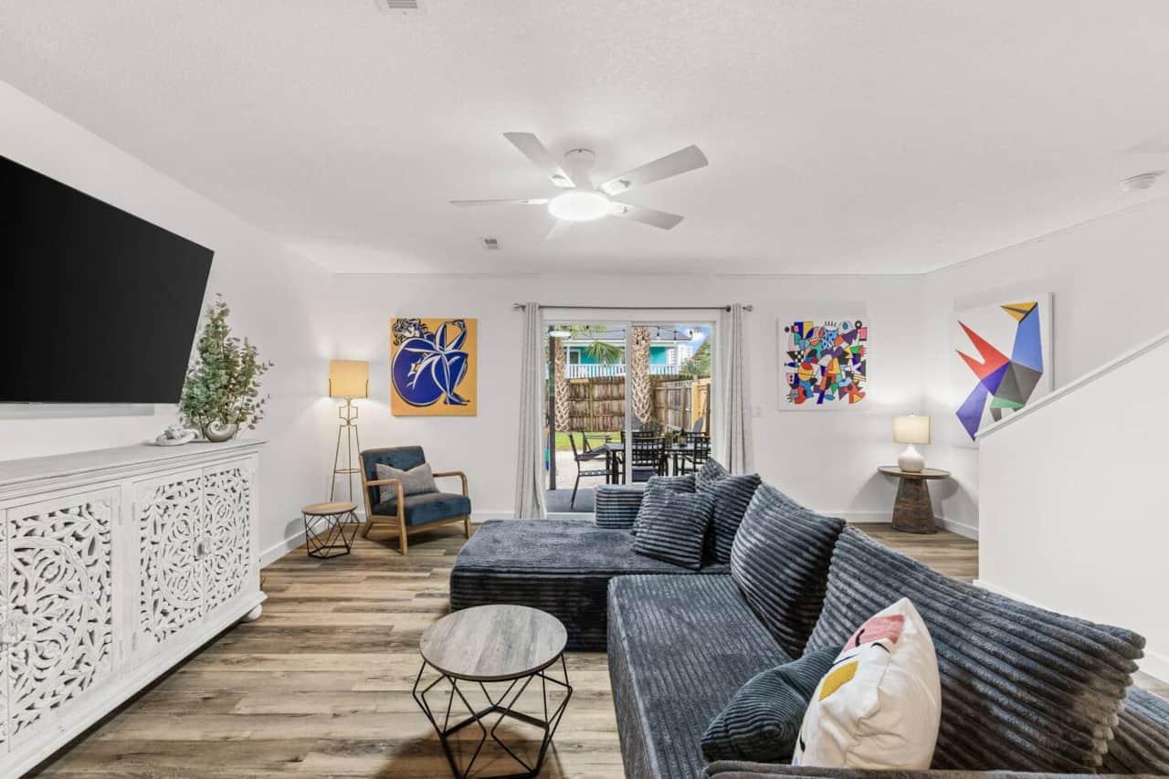 Relax on the oversized sectional with a large smart TV, high-speed Wi-Fi, and air conditioning. Colorful midcentury-inspired art brightens the room, while sliding doors lead straight to the covered dining patio, BBQ grills, and fenced backyard