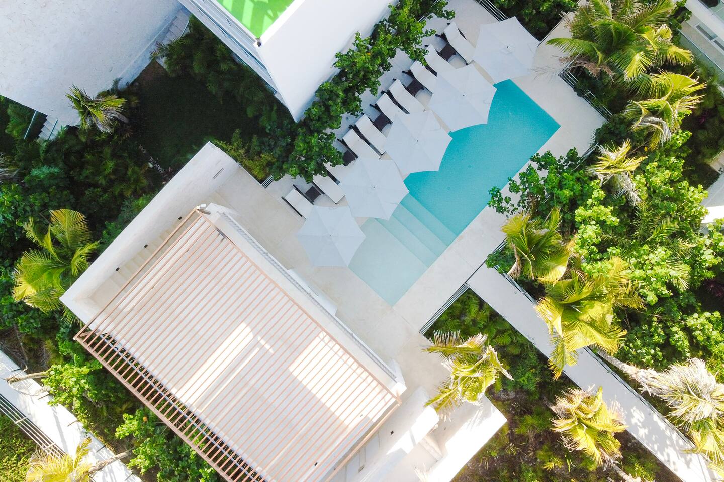Impresionante vista aérea de los exuberantes jardines y la serena piscina, con acceso a nuestra tranquila terraza de yoga en la azotea, perfecta para estiramientos al amanecer y relajación.