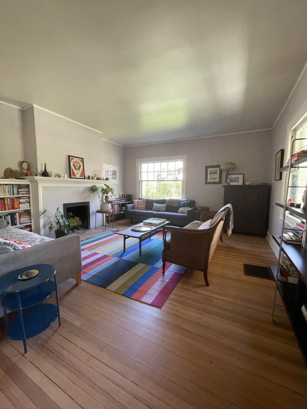 Light-filled living room with original architectural details—comfortable, open, and easy for gathering. Great book collection and record player.