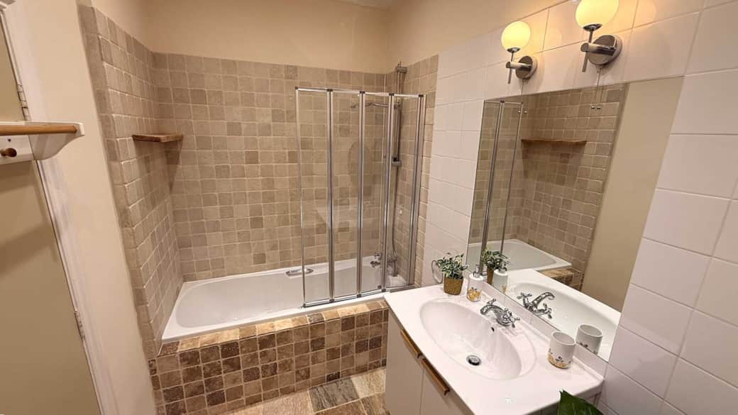 The family bathroom is spacious with a bathtub and a shower screen The family bathroom is spacious with a bathtub and a shower screen