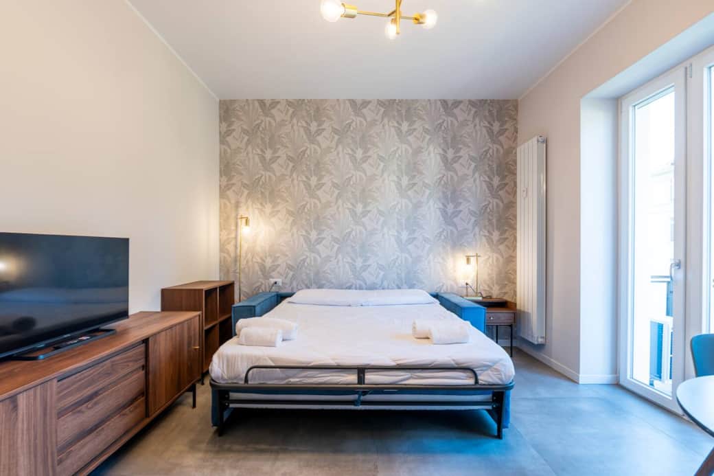 soggiorno accogliente con divano letto, tv e tavolo da pranzo