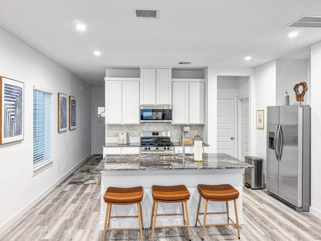 Fully equipped Kitchen with 3 bar stools for extra seating in open area combined with Livingroom and Diningroom.