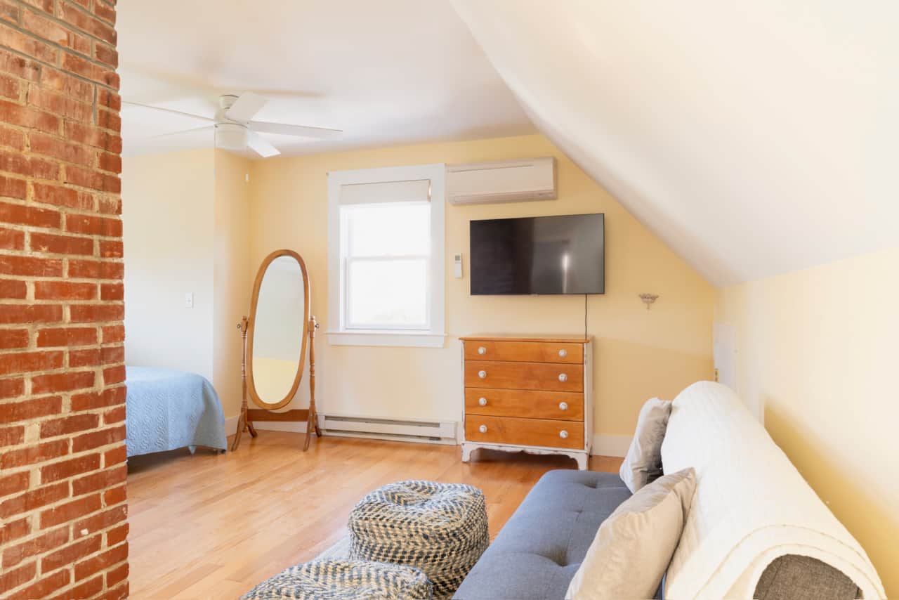Second floor loft space with smart TV and couch seating is a perfect spot for kids