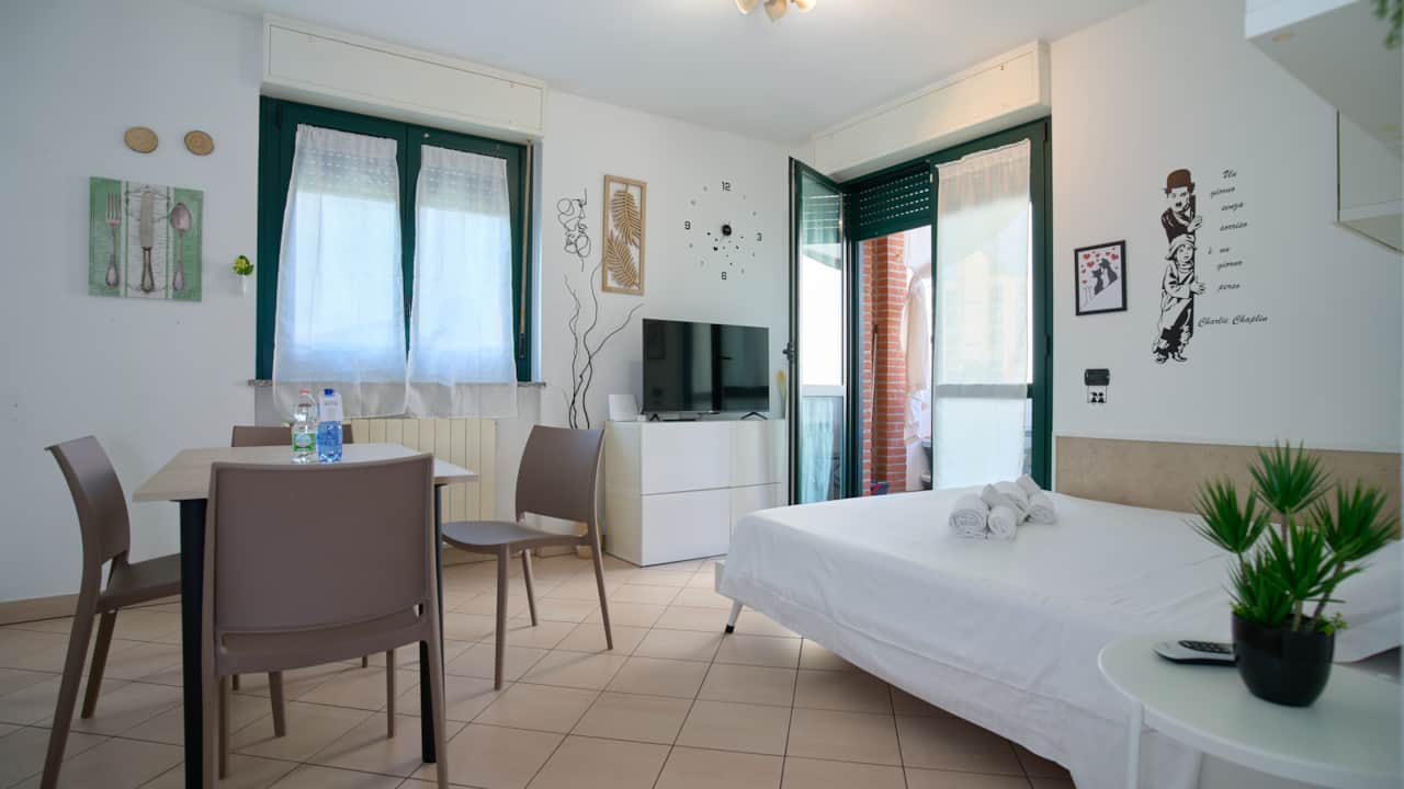 Open-plan space with dining table, sofa and open kitchen, in Monza
