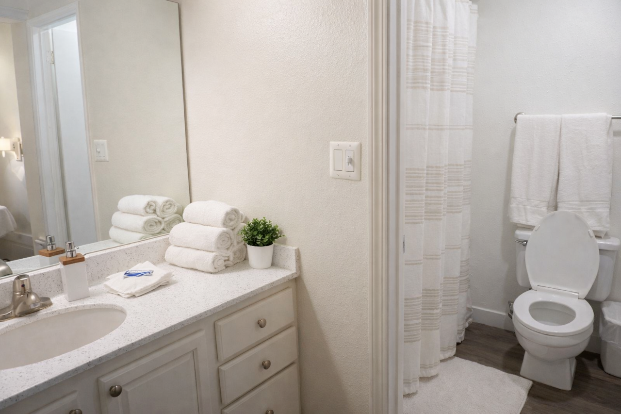 Bright, minimalist bathroom featuring a  tub and all the essentials thoughtfully stocked.