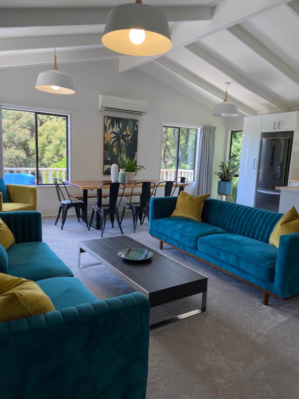 Teal sofas, timber dining table, the heart of The Nest