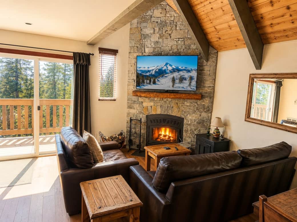 Cozy living room with wood burning fireplace, smart tv, and leather couches Cozy living room with wood burning fireplace, smart tv, and leather couches
