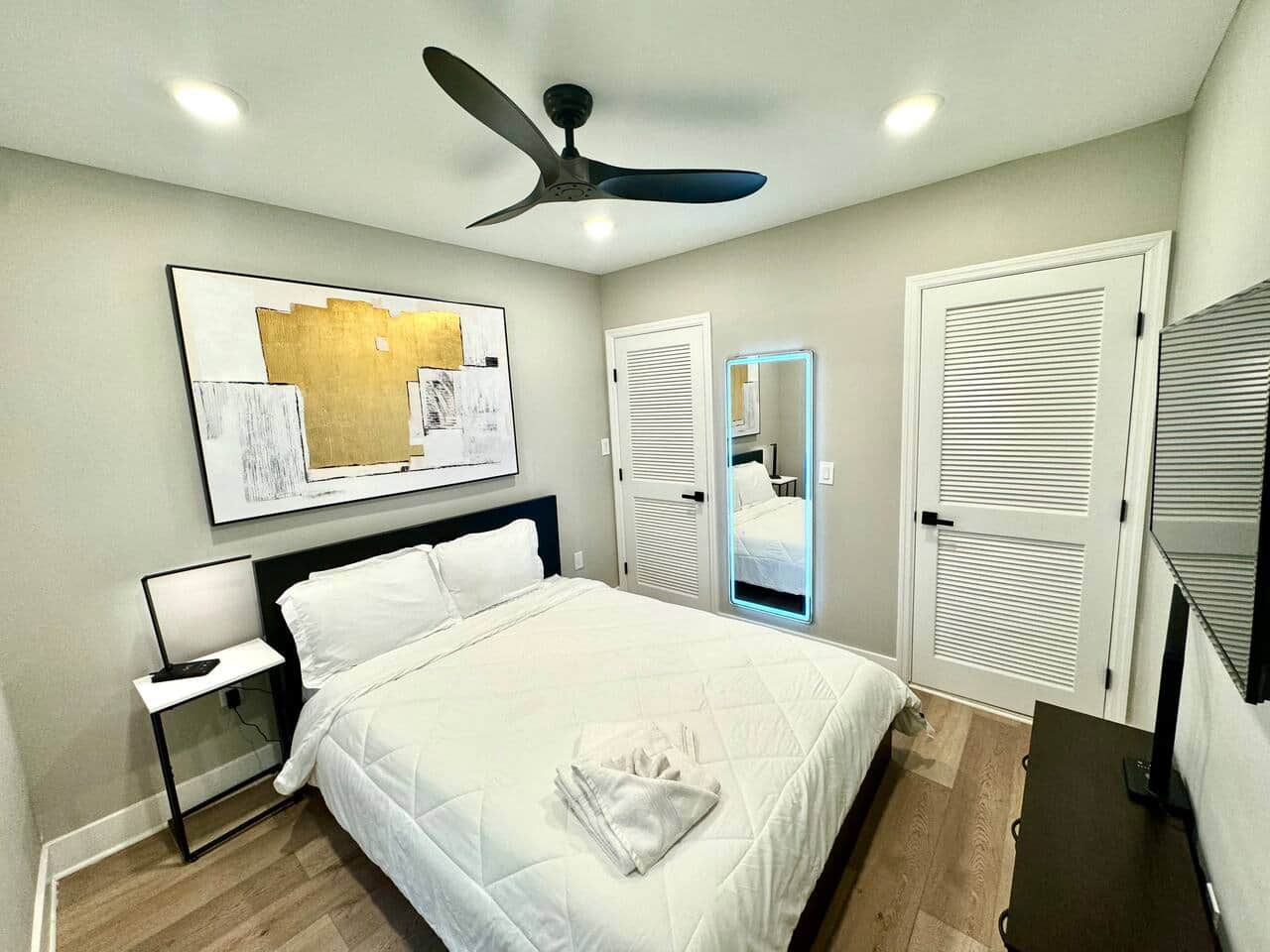 This comfortable bedroom includes a queen bed, flat-screen TV, ceiling fan, darkening curtains, a side table, USB charging, lamp, and a spacious closet for all your storage needs.