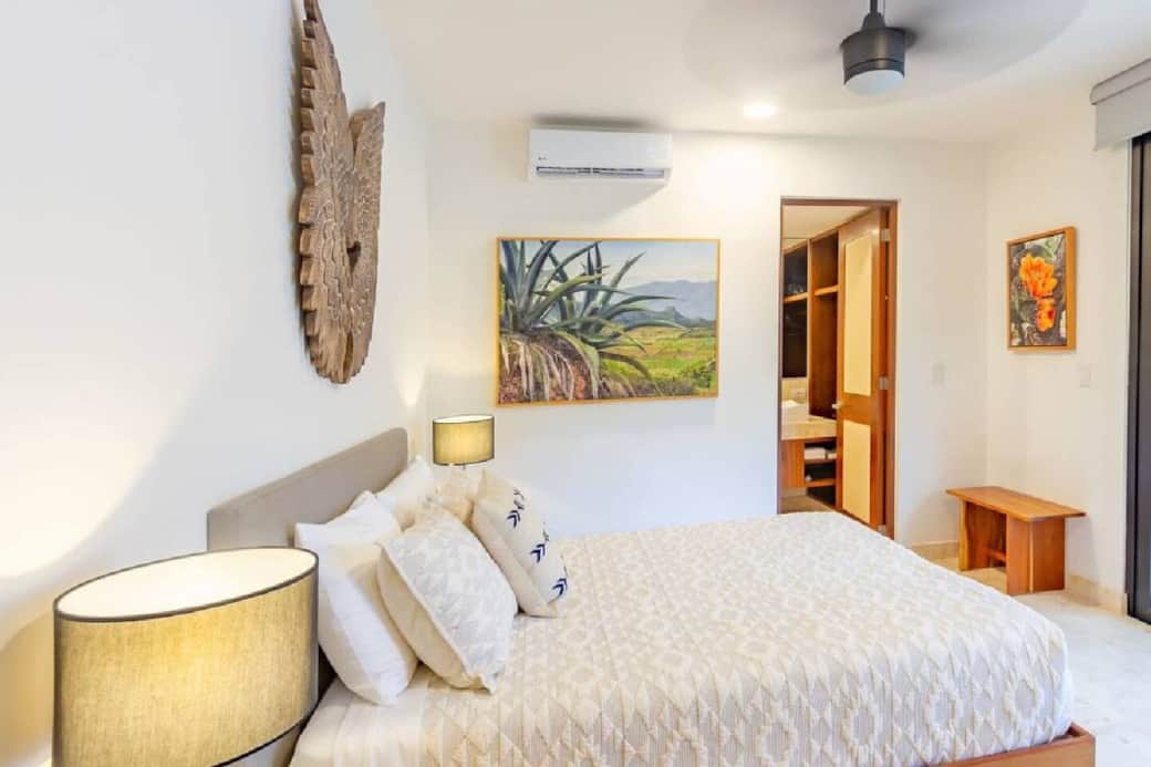 Rest easy in the bedroom featuring a comfortable queen bed, air conditioning, and a ceiling fan for a cool, relaxing sleep. The room includes a private ensuite bathroom, offering comfort and convenience throughout your stay.