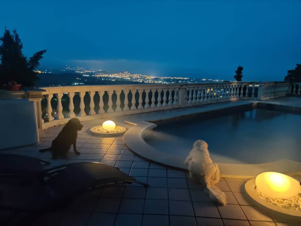 Night time at the pool with a view across the valley towards the sea.