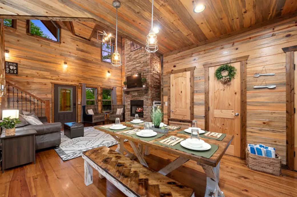 This cabin brings the outdoors in with soaring ceilings, a two story fireplace, smart TV, and open l