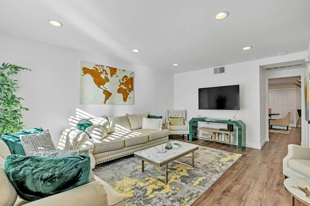A haven of natural light, this airy living room features a comfortable sofa and a large TV. It's the perfect place to lounge, enjoy a show, or read in the sunlight.