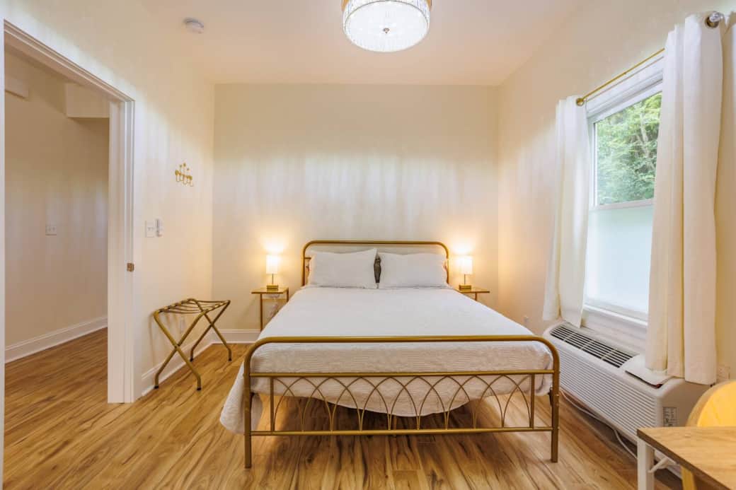 Primary bedroom with direct access to the bathroom. Queen bed, ceiling fan inside the light fixture (called a "fandelier"). Also an individually controlled air conditioner and heater, similar to hotels (called a PTAC). Primary bedroom with direct access to the bathroom. Queen bed, ceiling fan inside the light fixture (called a "fandelier"). Also an individually controlled air conditioner and heater, similar to hotels (called a PTAC).