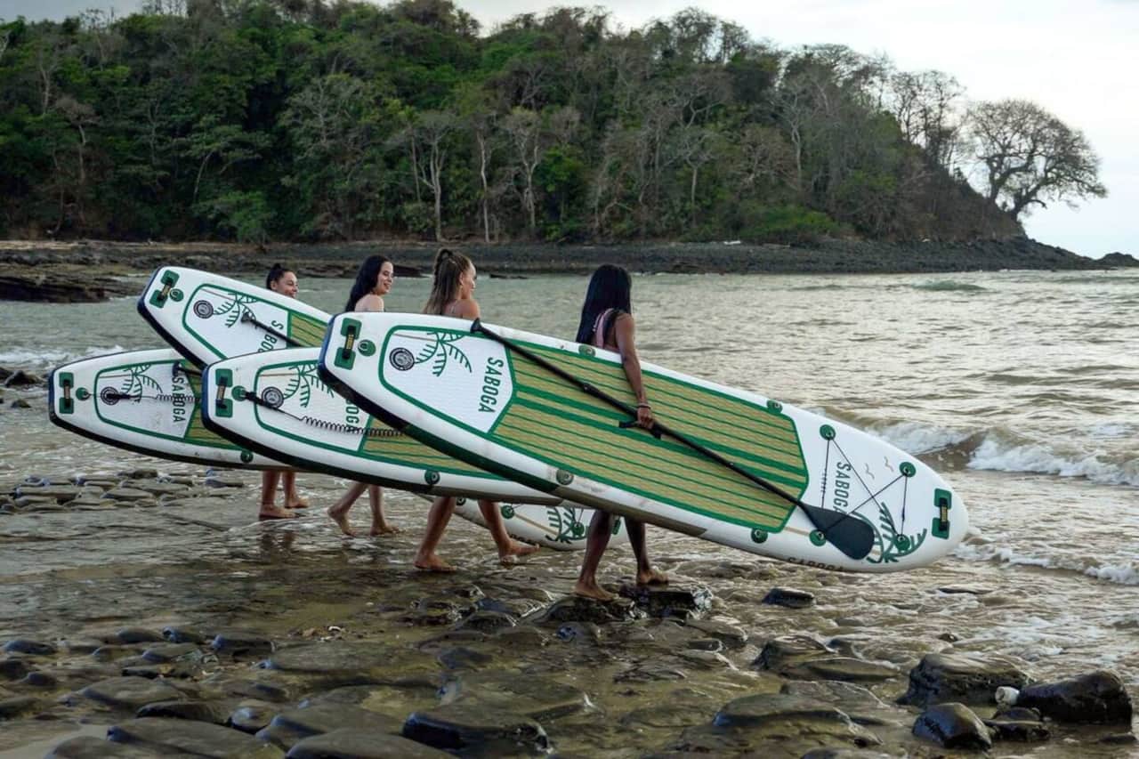 Carrying SABOGA stand up paddle boards over the rocky shore near Saboga Lodge, Panama