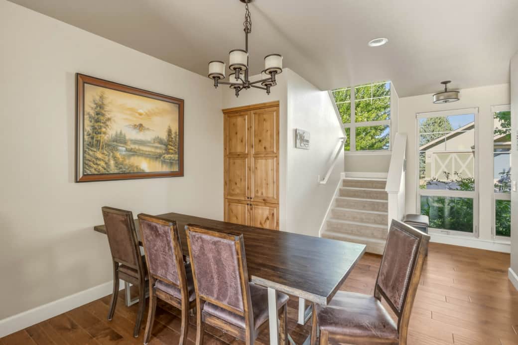 Dining area seats six, with chandelier and hardwood floors — plus bar seating for three.