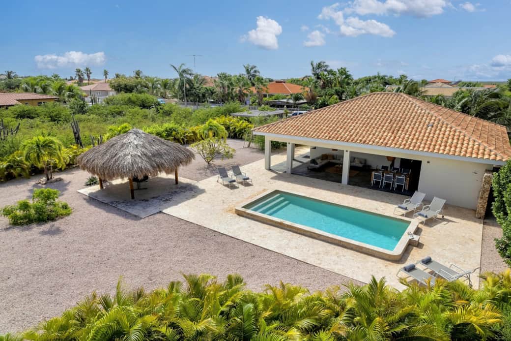 Tropische tuin bij Palm Villa Bonaire vol palmbomen en rust
