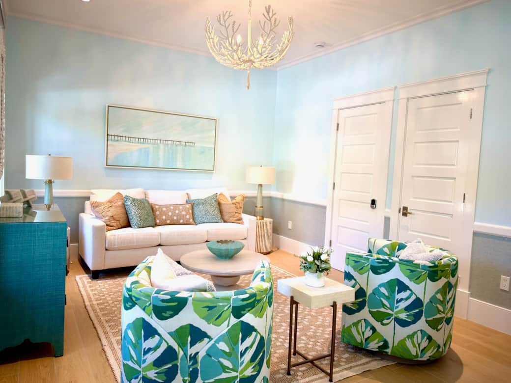 Bright living room near the entry with elegant coastal-modern style and cozy seating.