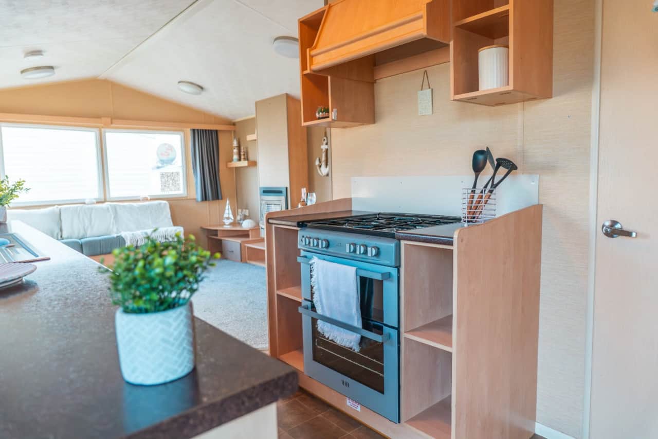 Kitchen with oven and hob, opening into the living area.