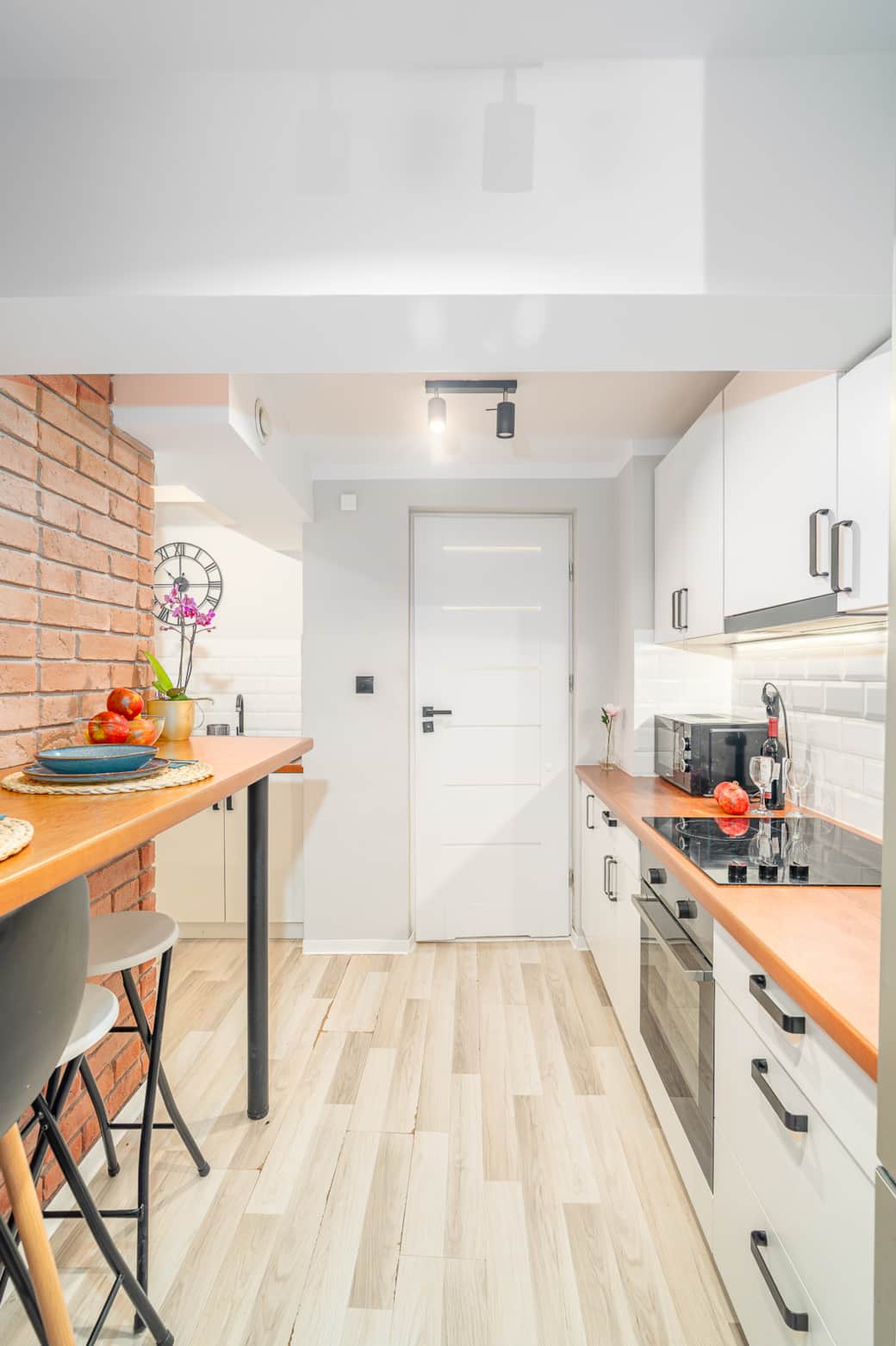 Jasna kuchnia z pełnym wyposażeniem, ergonomicznym układem i wysokim blatem do codziennych posiłków.