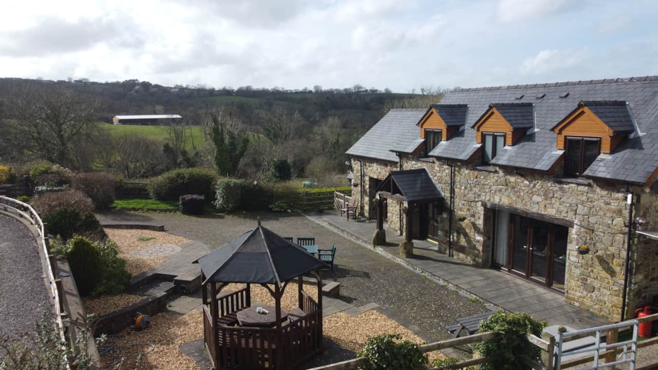 Wide aerial view of the cottage nestled in the valley