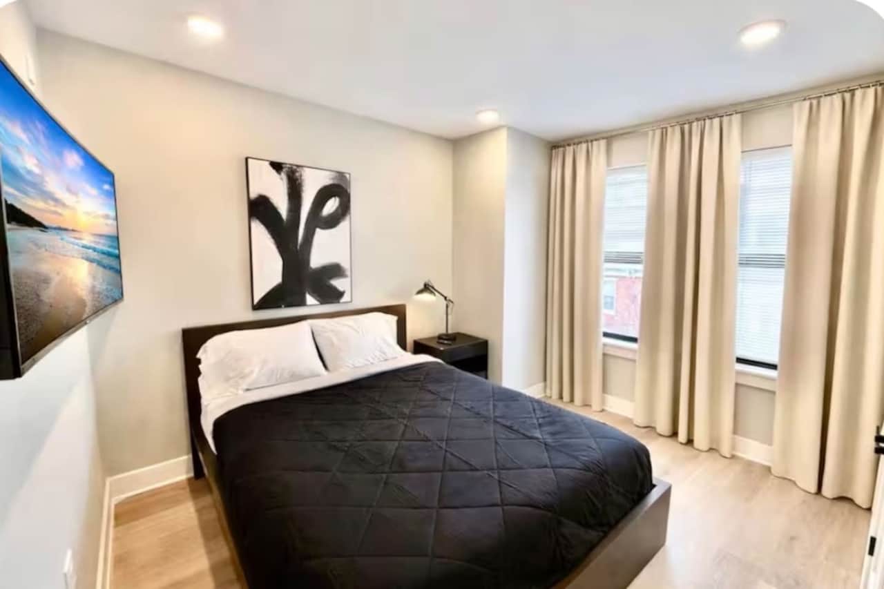 bedroom with queen bed, flatscreen TV and a large closet.