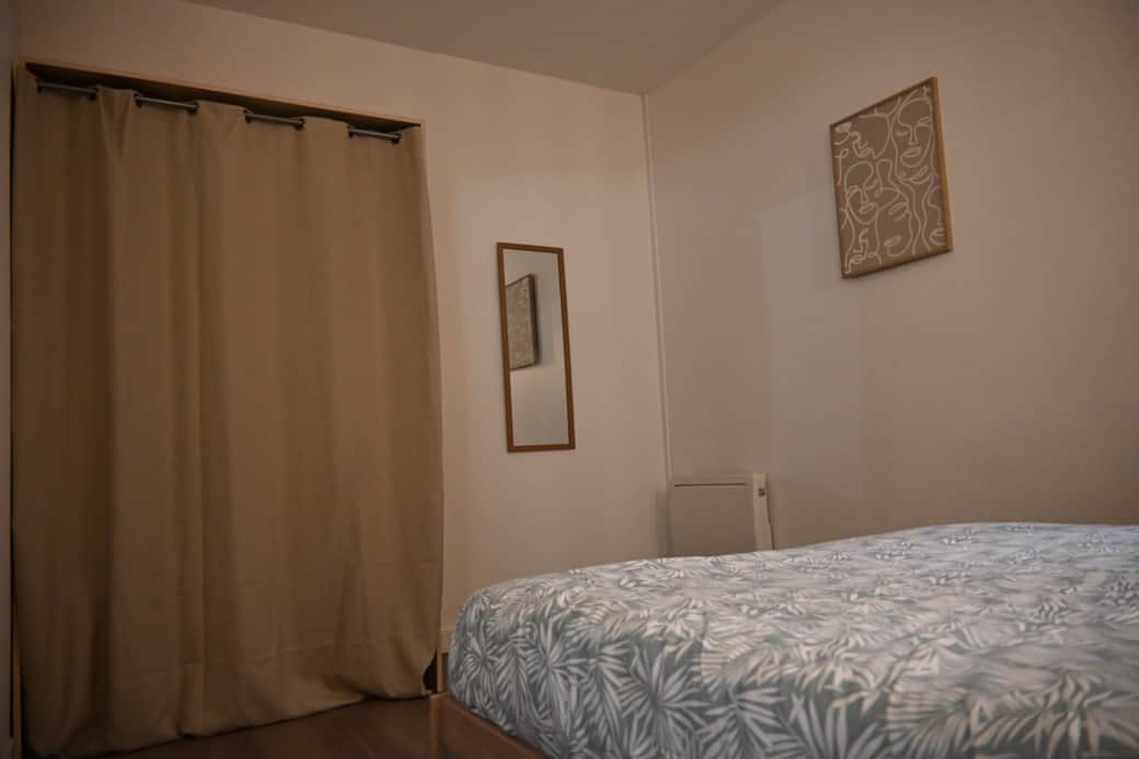 Chambre cosy avec lit double, ambiance chaleureuse et décoration épurée.