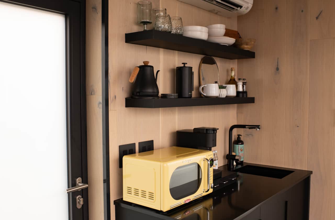 Compact kitchenette with essentials for simple meals, blending modern function with cozy cabin style