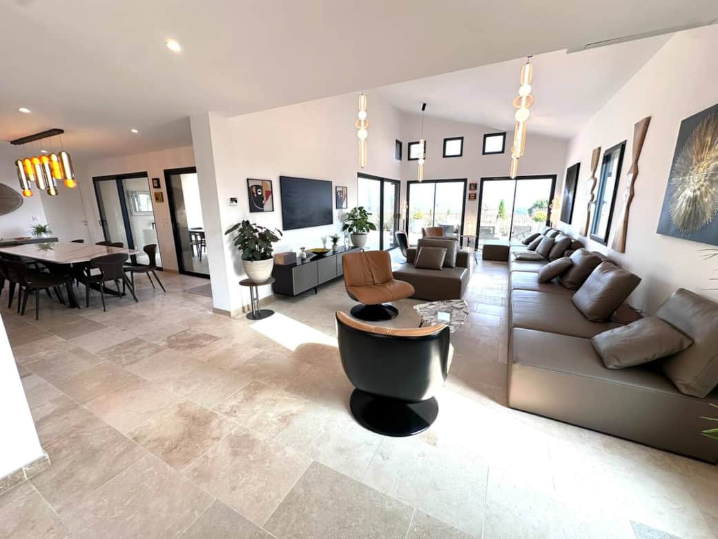 Living room with seating for 12, large screen TV and sliding doors with views of the mountain.