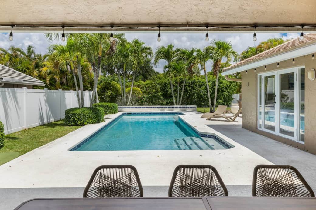 Experience the stunning view of our beautiful backyard oasis from our relaxing patio, complete with a large table for gatherings and ceiling fans to beat the Florida sun.