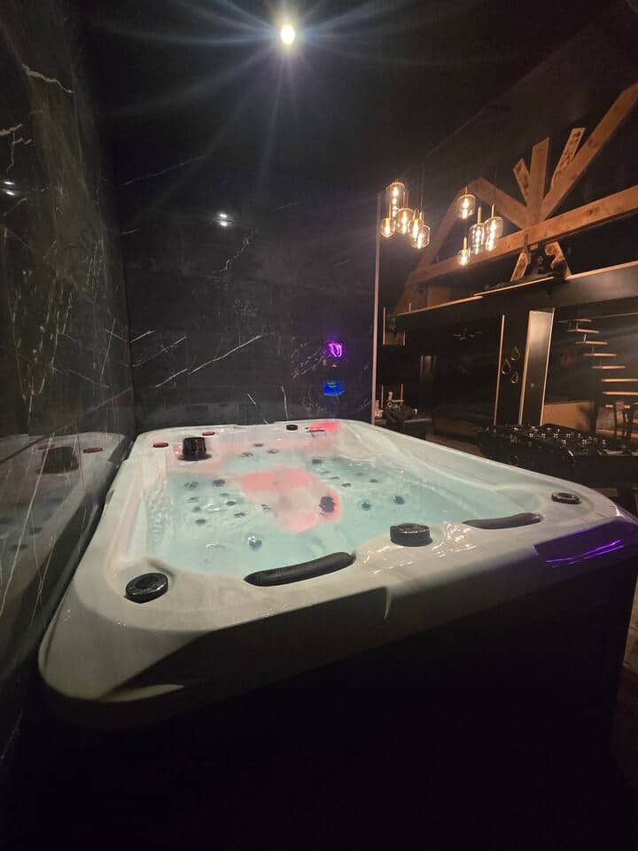 Jacuzzi sur une petite plateforme sur le coté de la pièce. Système BALBOA. équipé de LED, porte verre et d'un marche pied pour y entrer. 2 véritables places allongées 