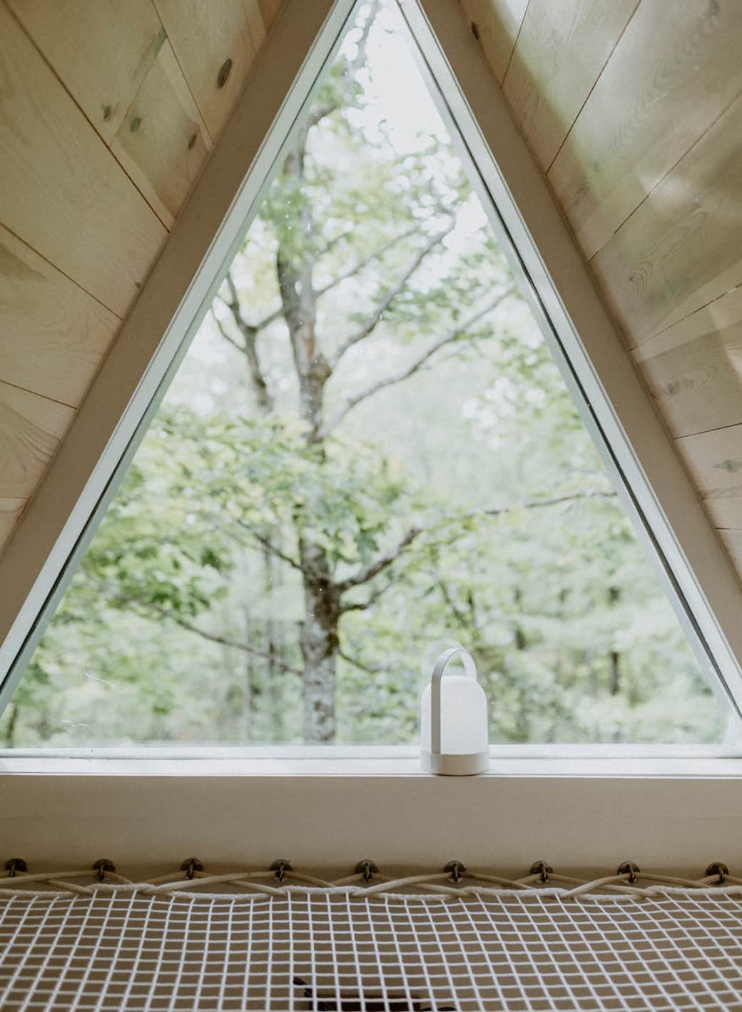 Le loft et sa fenêtre iconique — relaxer face aux arbres. Crédit photo: @roblloyd_